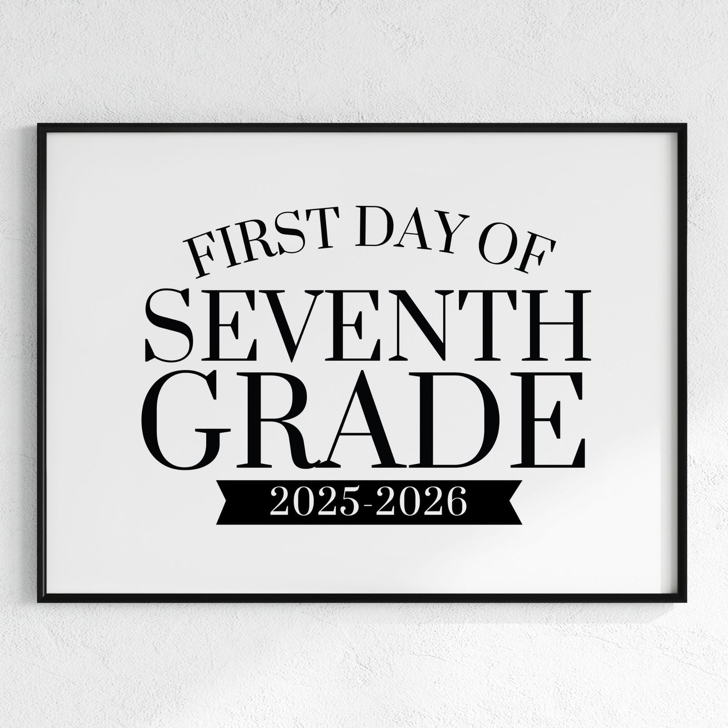 Framed poster with 'First Day of Seventh Grade 2025-2026' text on a white wall.