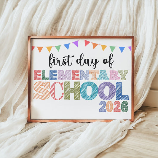 Framed sign with 'first day of elementary school 2026' text on a soft fabric background