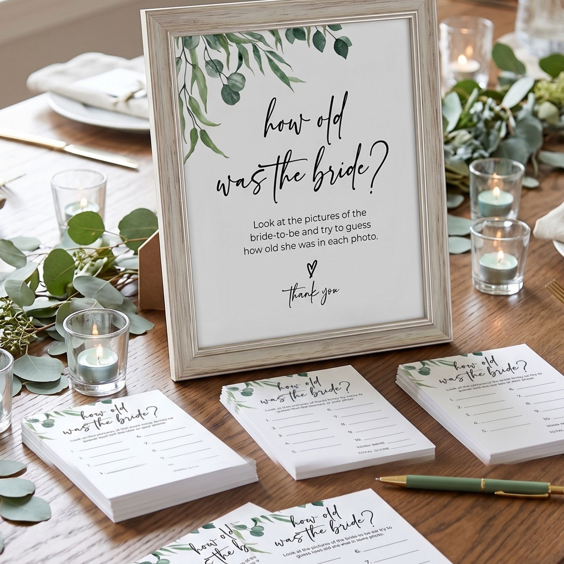 Wedding game cards titled 'How old was the bride?' on a table with candles and greenery.