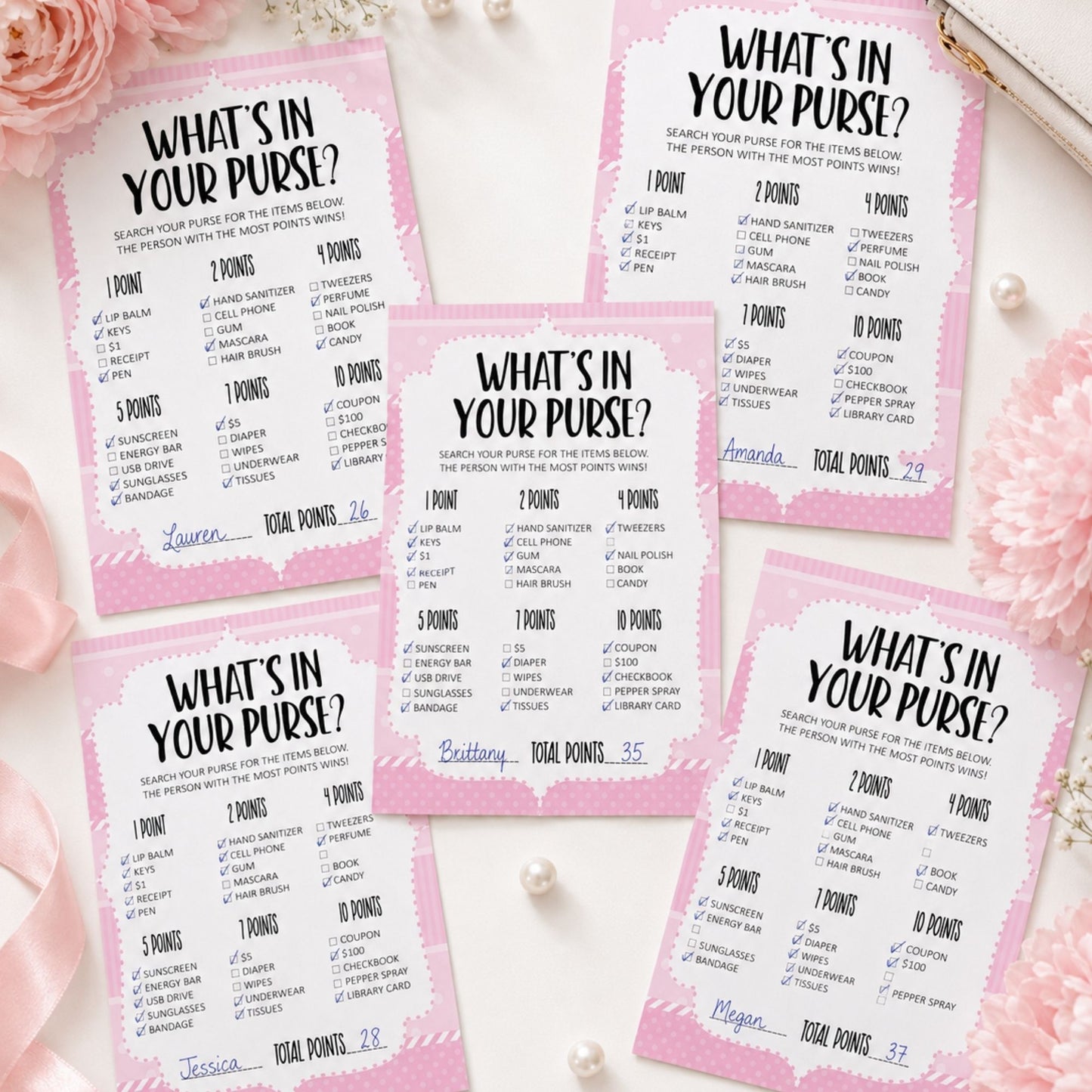 Five pink and white 'What's in your purse?' game cards arranged on a white surface with pink roses and pearl beads.