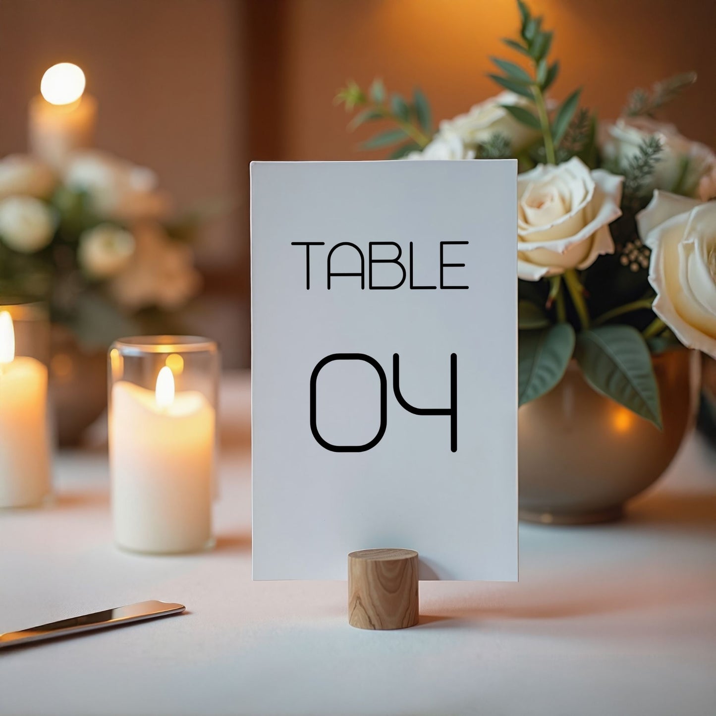 Table number 04 card on a table with candles and flowers