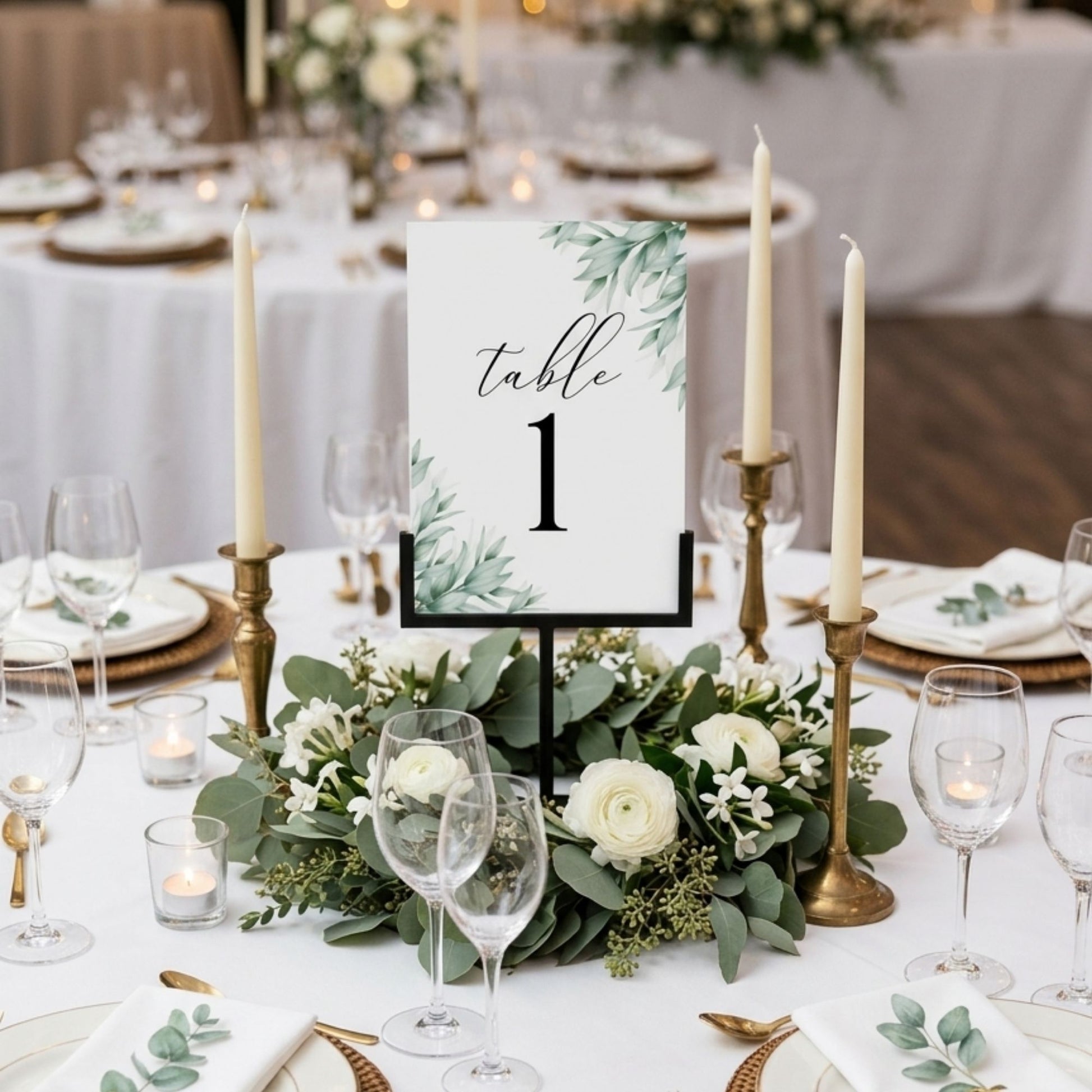 Elegant table setting with floral centerpiece, candles, and a table number card.