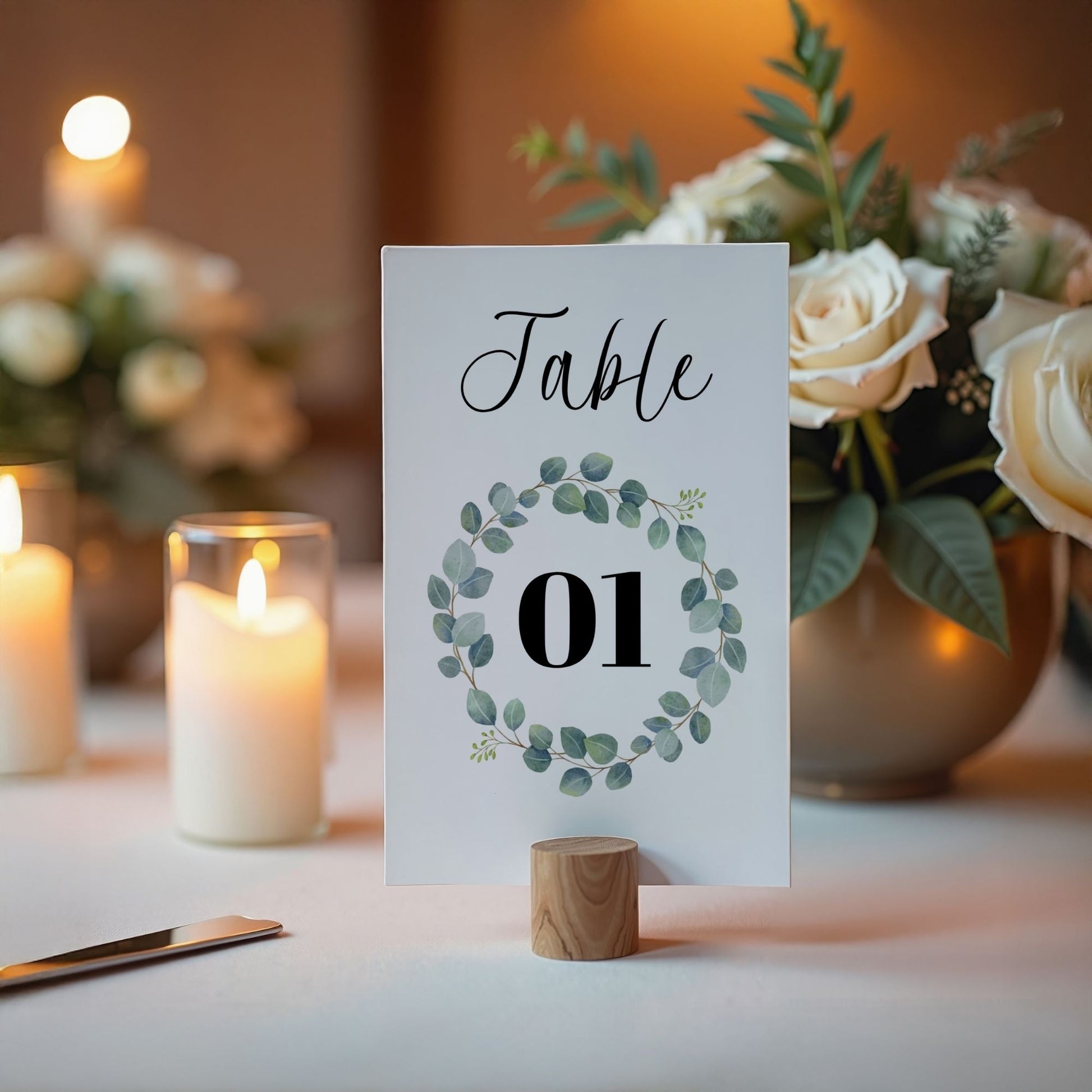 Table number card with floral design on a table with candles and flowers