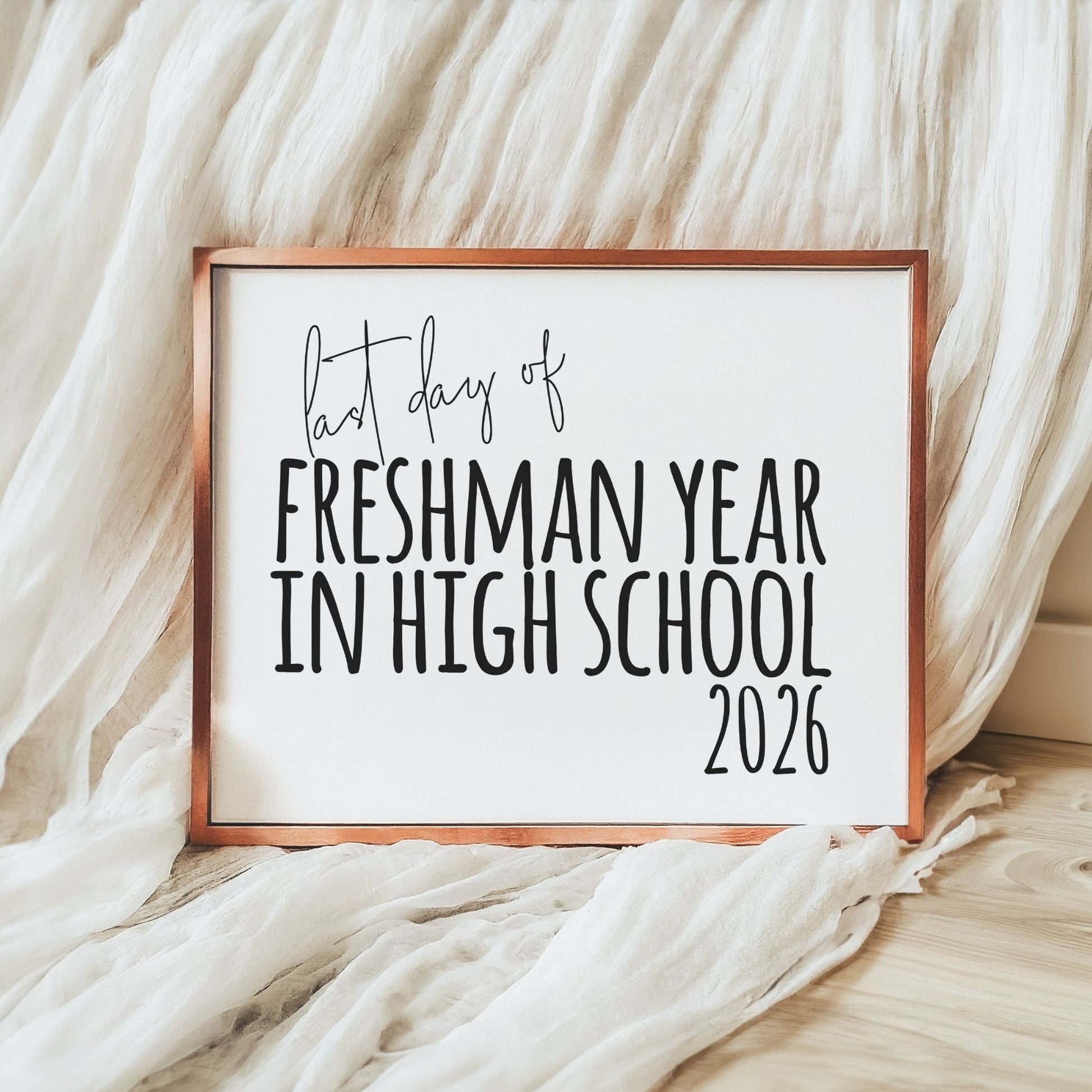 Framed sign with 'Last day of Freshman Year in High School 2026' text on a soft fabric background