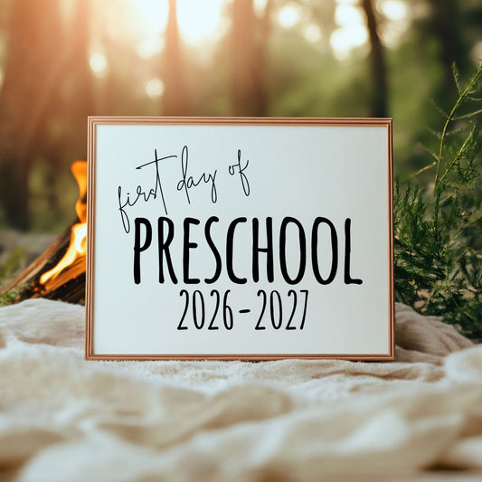 Framed sign with 'first day of preschool 2026-2027' text against a natural background.