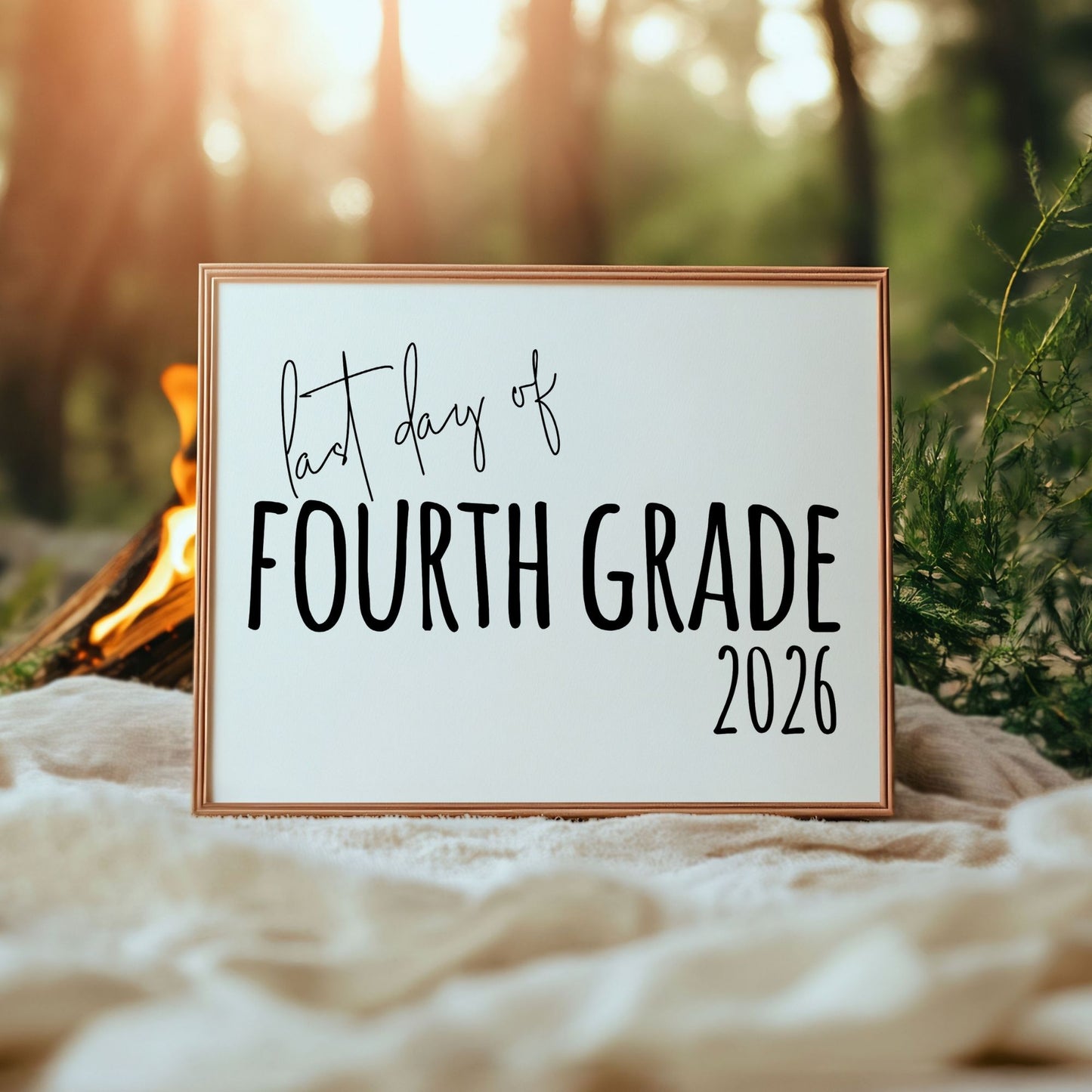 Framed sign with 'First day of Fourth Grade 2026' text against a natural background.