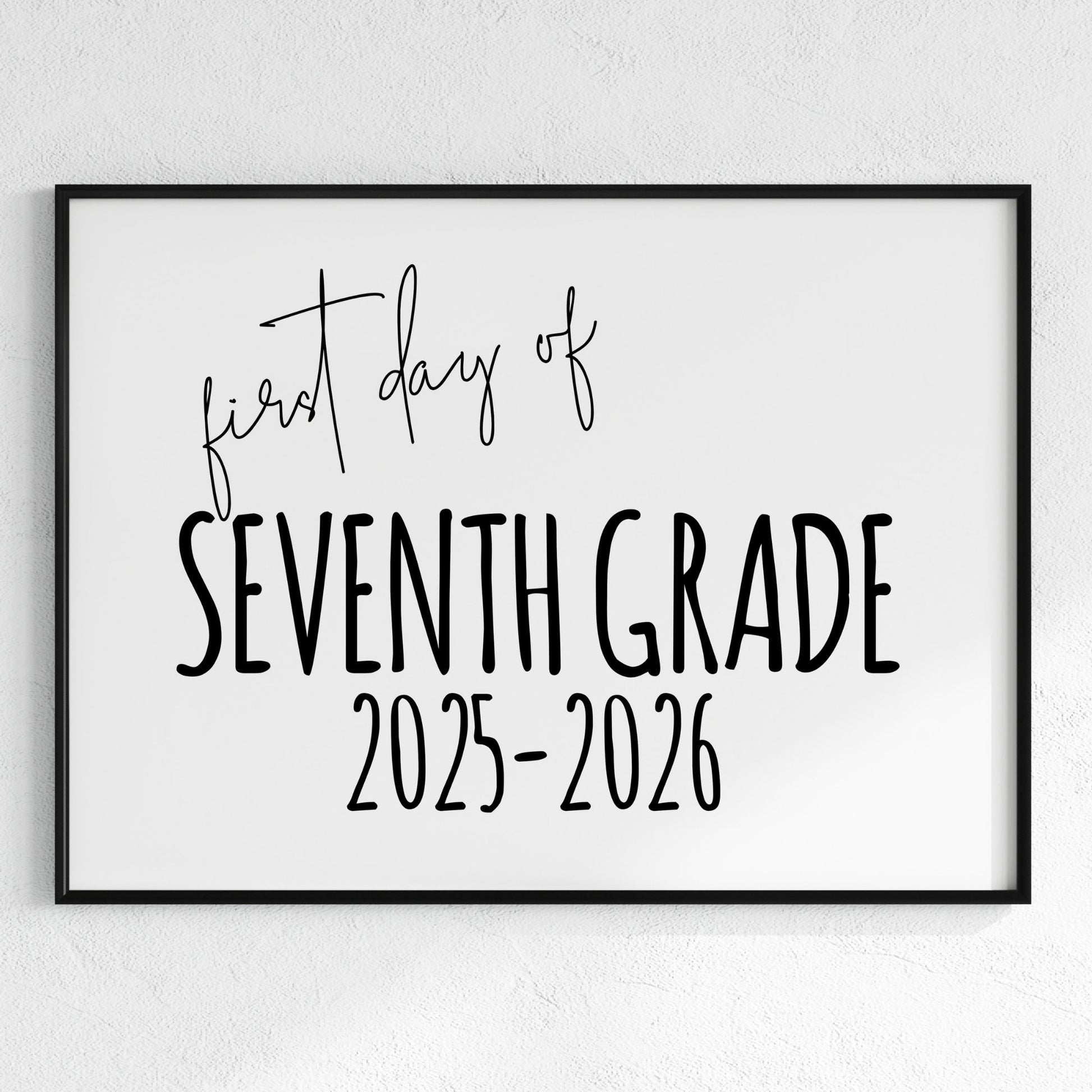 Framed sign with 'first day of Seventh Grade 2025-2026' text on a white wall.