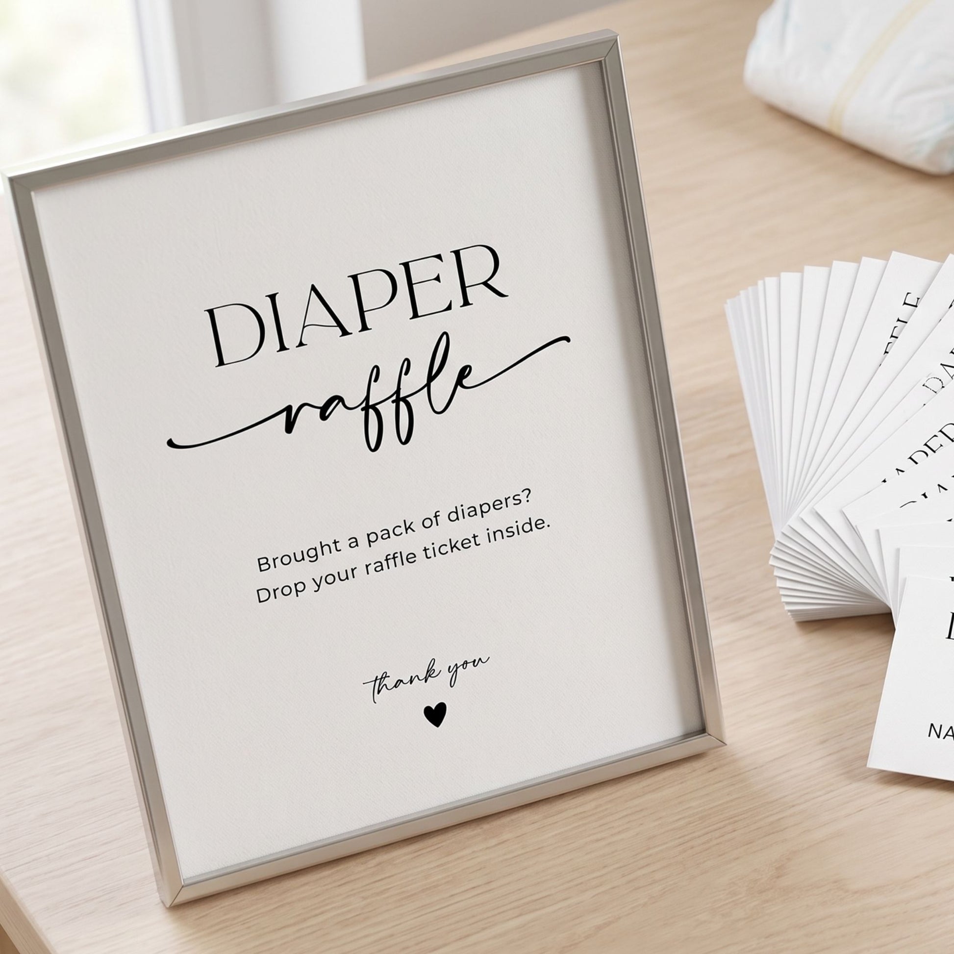 Framed sign for a diaper raffle with raffle tickets on a wooden surface