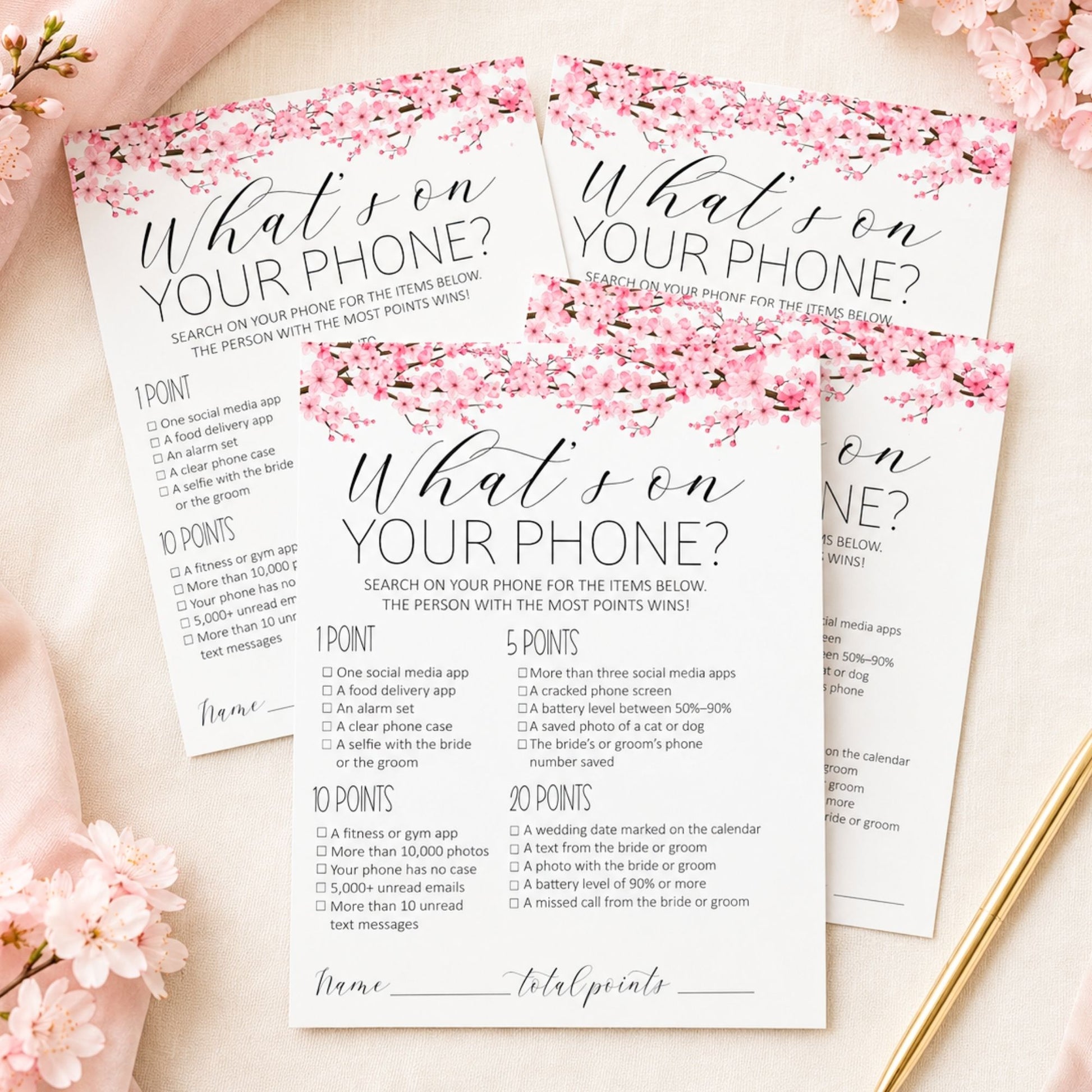 Three floral 'What's on your phone?' reward chart templates arranged on a light beige surface with pink blossoms and a gold spoon as styled props.