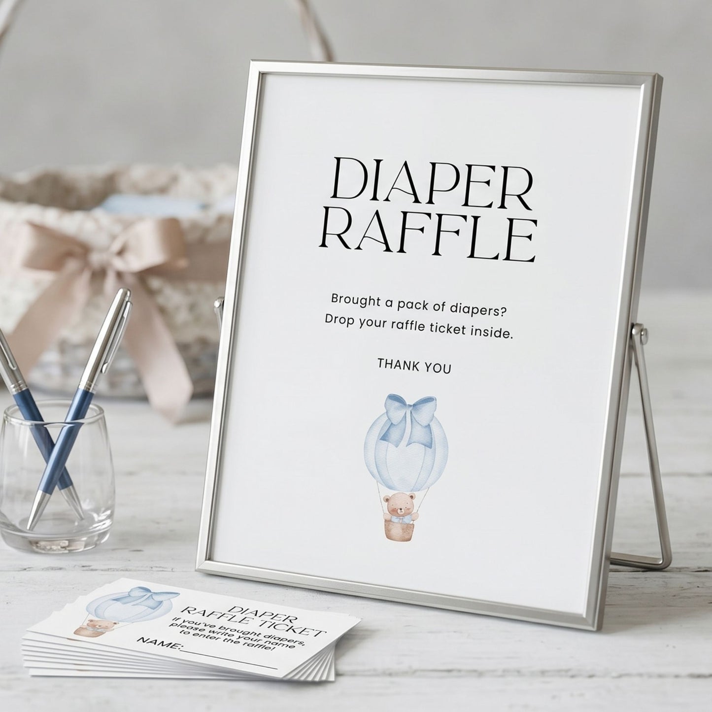 Framed 'Diaper Raffle' sign with raffle tickets on a table.