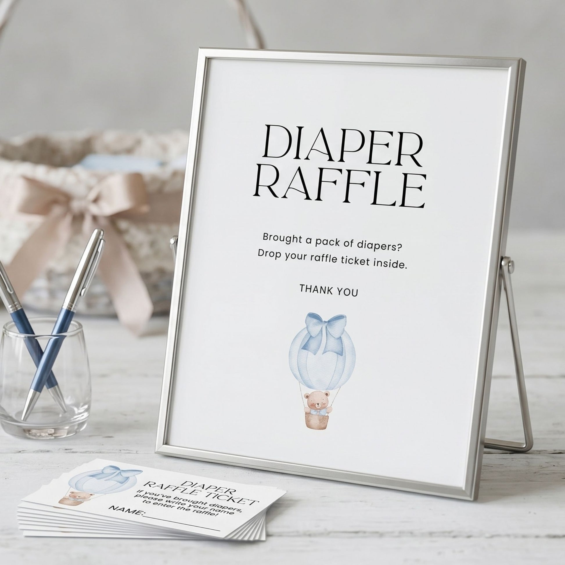 Framed 'Diaper Raffle' sign with raffle tickets on a table.