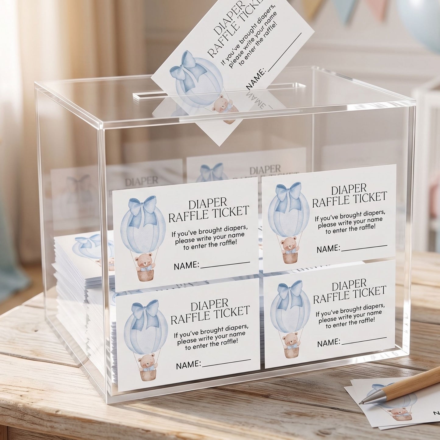 Clear acrylic box with diaper raffle tickets on a wooden surface