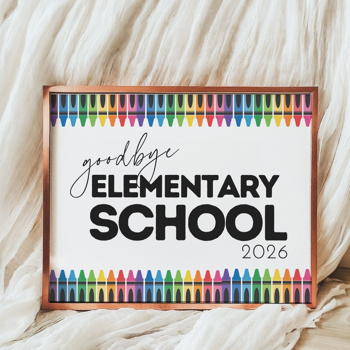 Framed sign with 'goodbye Elementary School 2026' text and colorful crayon designs on a soft fabric background.