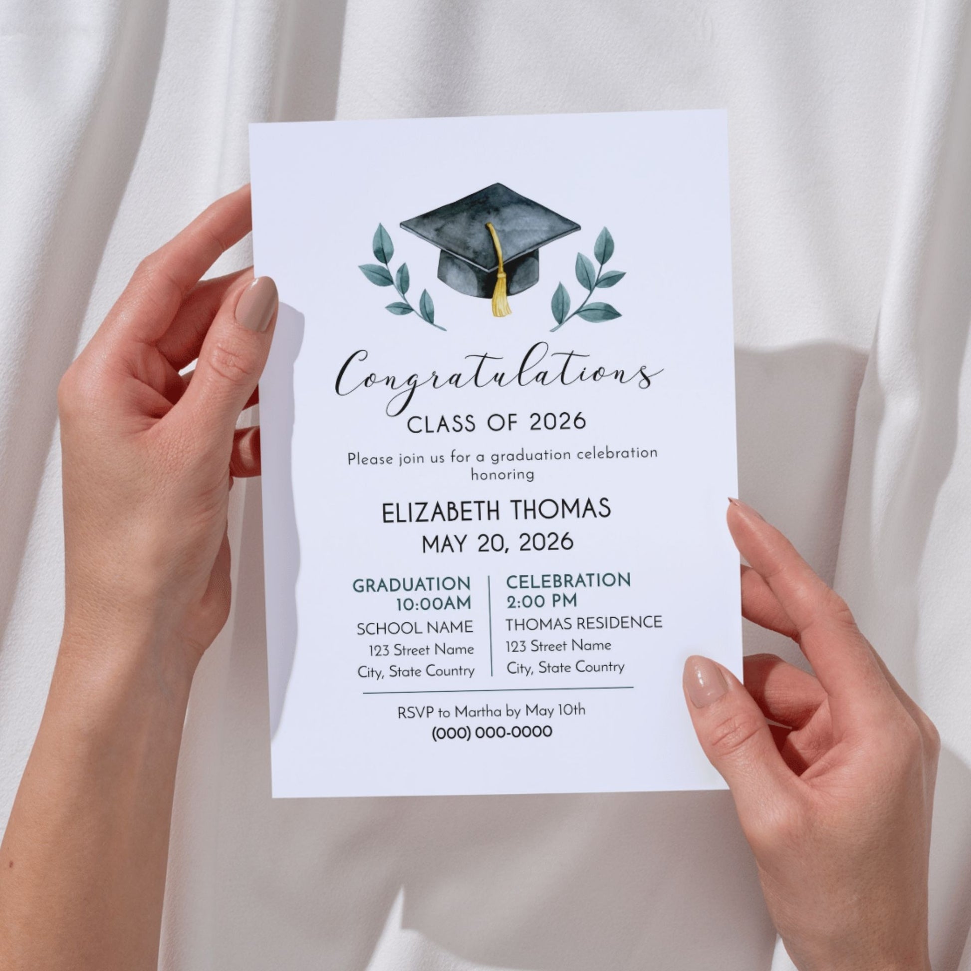 A pair of hands holds a vertical 5x7 graduation invitation. The design features a watercolor-style black graduation cap with a gold tassel, flanked by green leafy branches. The text reads "Congratulations Class of 2026" in a mix of script and serif fonts, honoring Elizabeth Thomas on May 20, 2026. Details for a 10:00 AM graduation and a 2:00 PM celebration at the Thomas Residence are included.