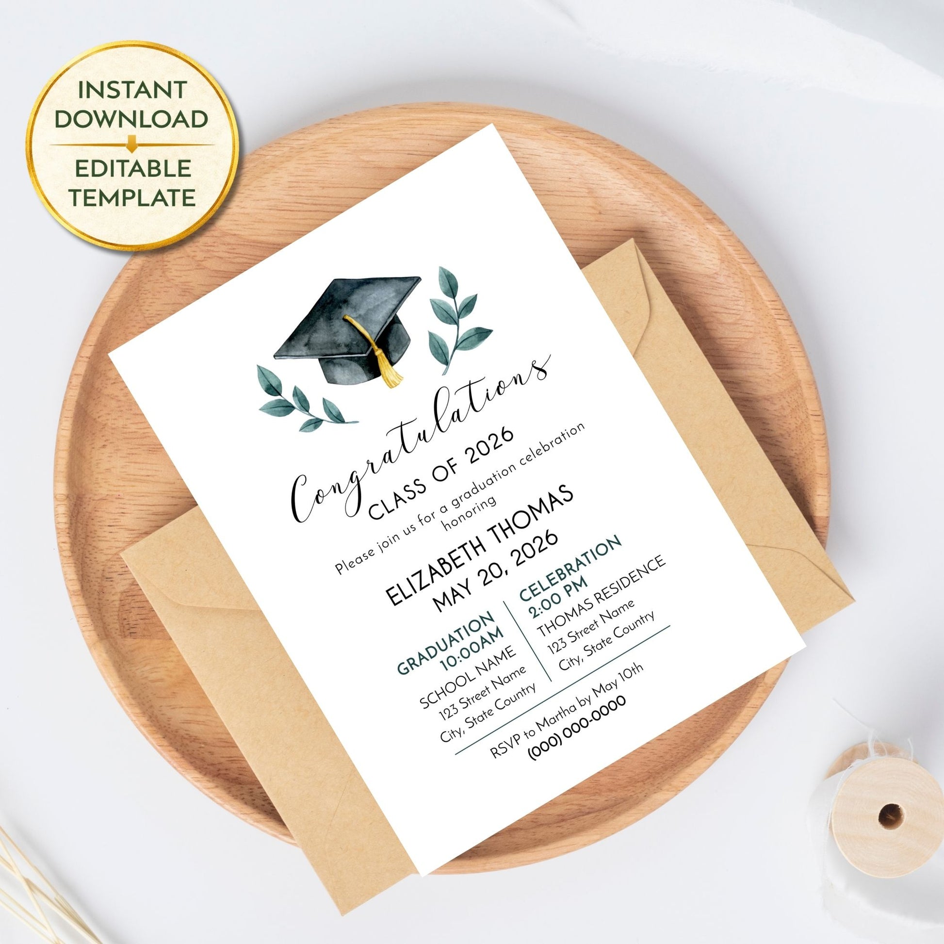 A graduation invitation sits on a kraft paper envelope, placed on a light wood circular tray. A gold "Instant Download Editable Template" seal is in the top left corner. The invitation features a watercolor graduation cap and greenery, with placeholder text for Elizabeth Thomas’s 2026 graduation ceremony and party.