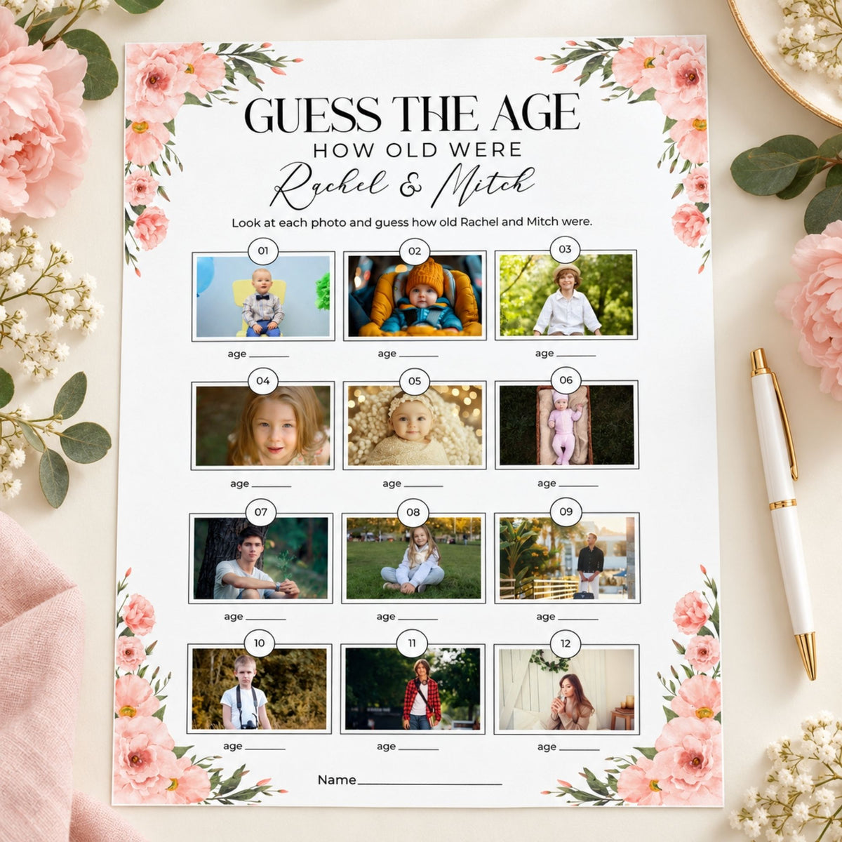 A floral 'Guess the Age' party game sheet featuring photos of a child from childhood with age placeholders, styled on a pink fabric surface with pink flowers, baby's breath, and a white pen.