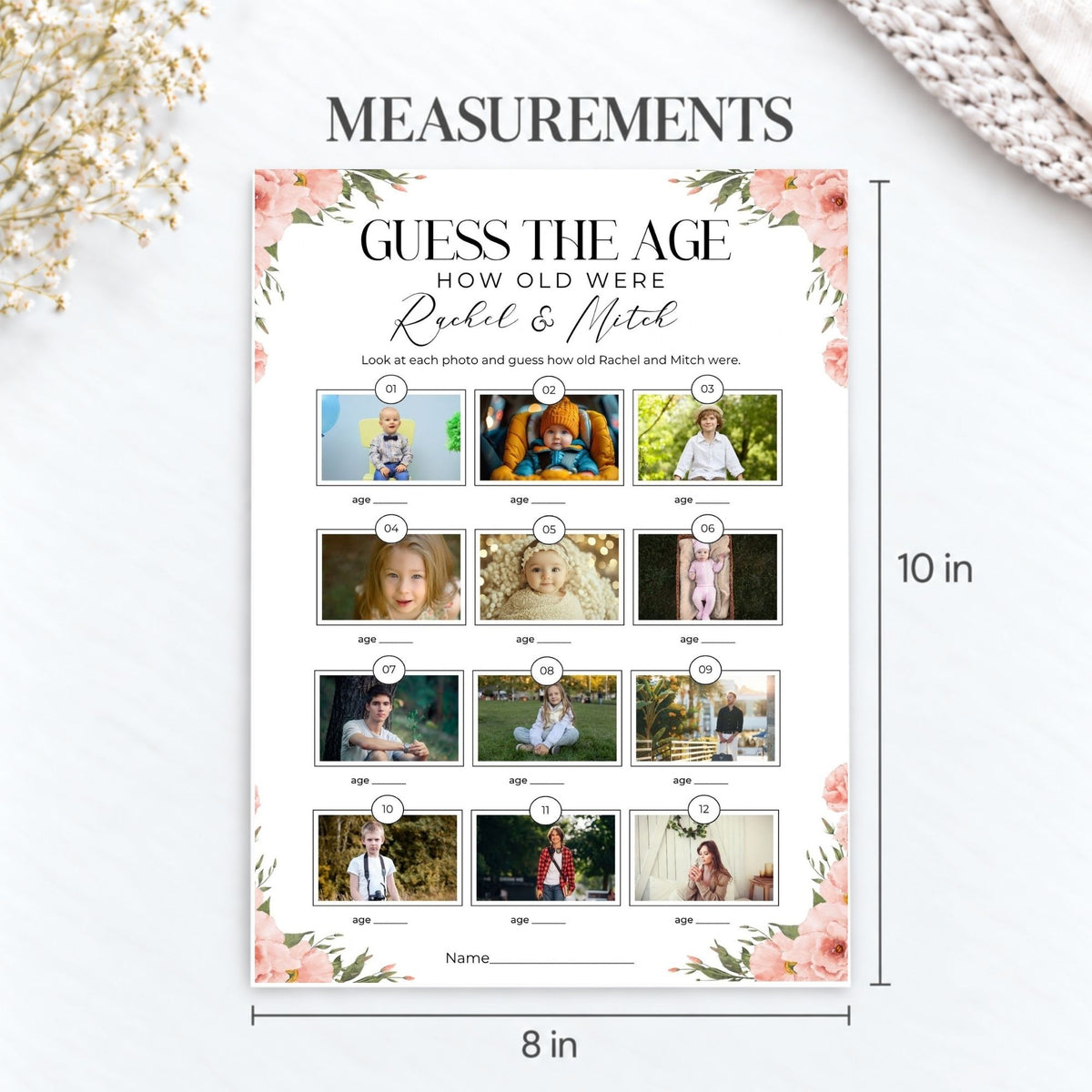 A personalized age-guessing measurement chart printed on a white sheet with pink floral corners, shown on a light surface with dimension labels reading 10 in tall and 8 in wide. The sheet includes placeholder photos and text reading 'Guess the Age' and 'How Old Were Rachel & Mitch.