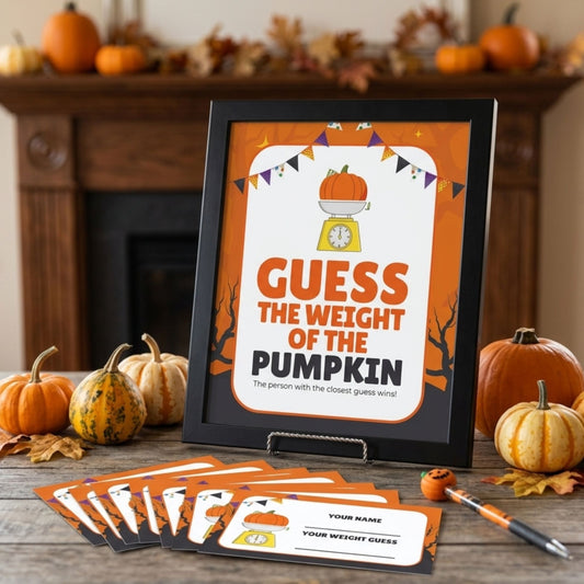 A framed Halloween party game card reading 'GUESS THE WEIGHT OF THE PUMPKIN' is displayed on a tabletop in a fall-themed setting with pumpkins, leaves, and a fireplace. Several matching game cards and a small pumpkin prop are arranged in front.