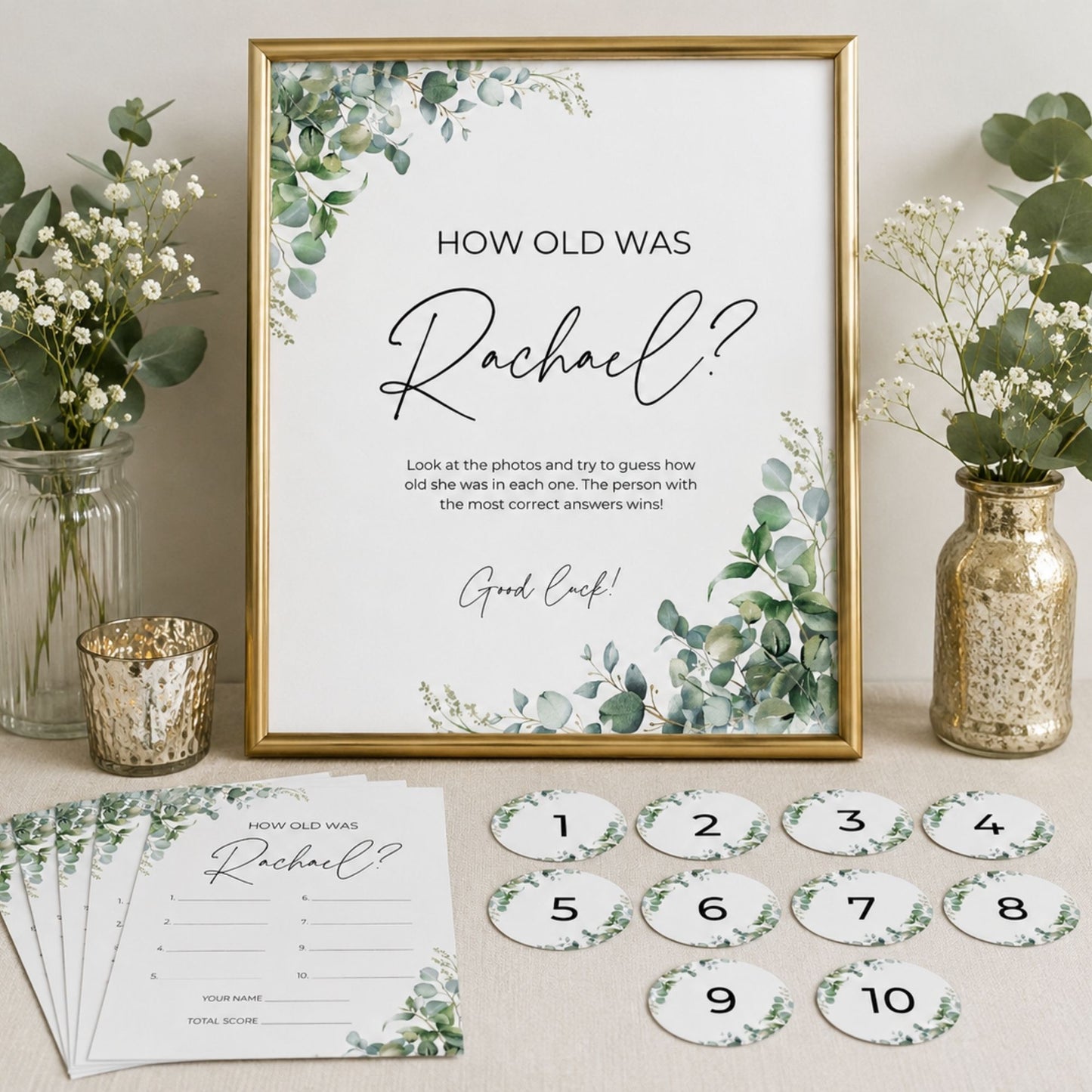 Decorative game board with 'How old was Rachael?' question and numbered cards on a table with floral arrangements.