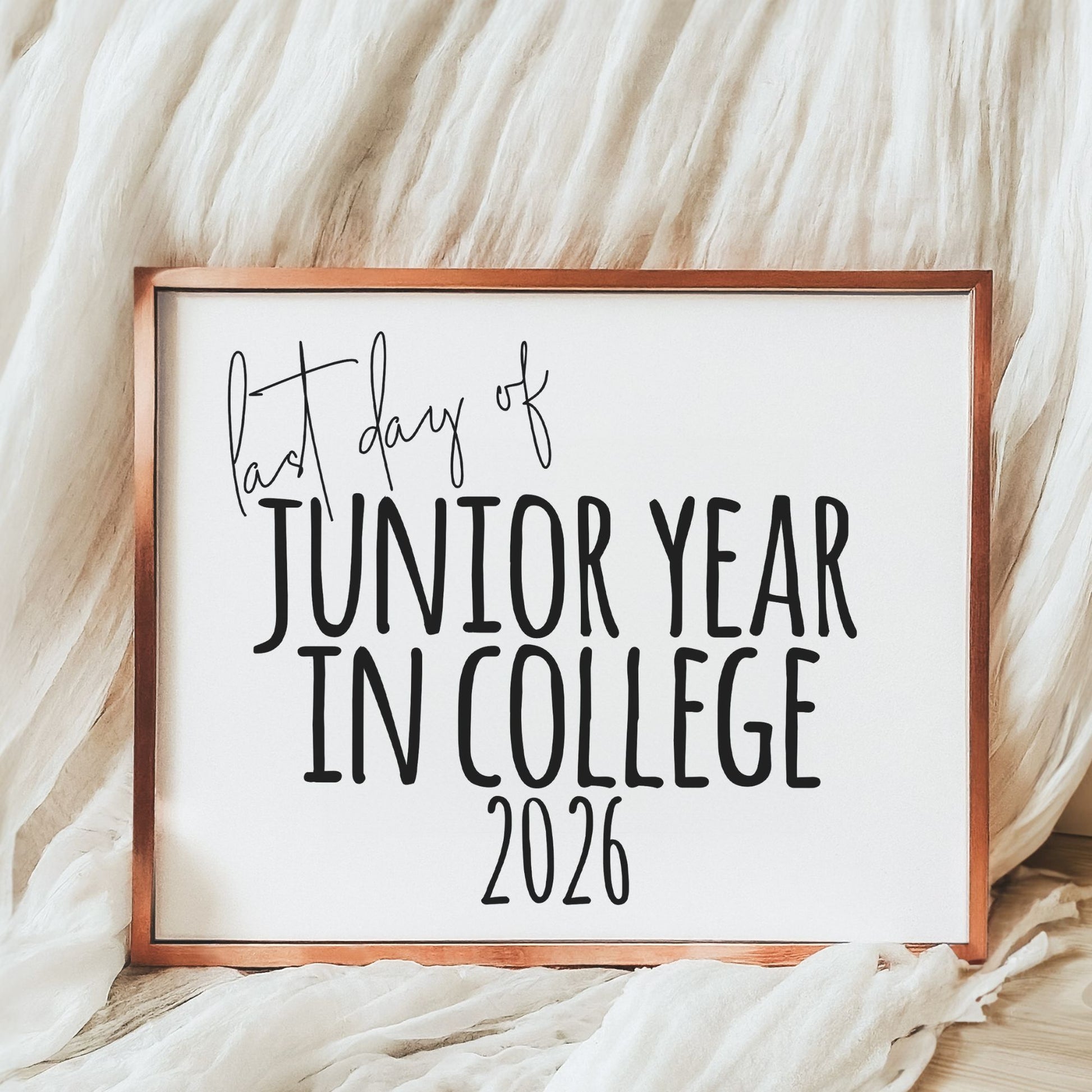 Framed sign with text 'Last day of Junior Year in College 2026' on a soft, textured background