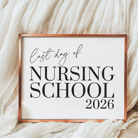 Framed sign with 'Last day of Nursing School 2026' text on a soft beige background