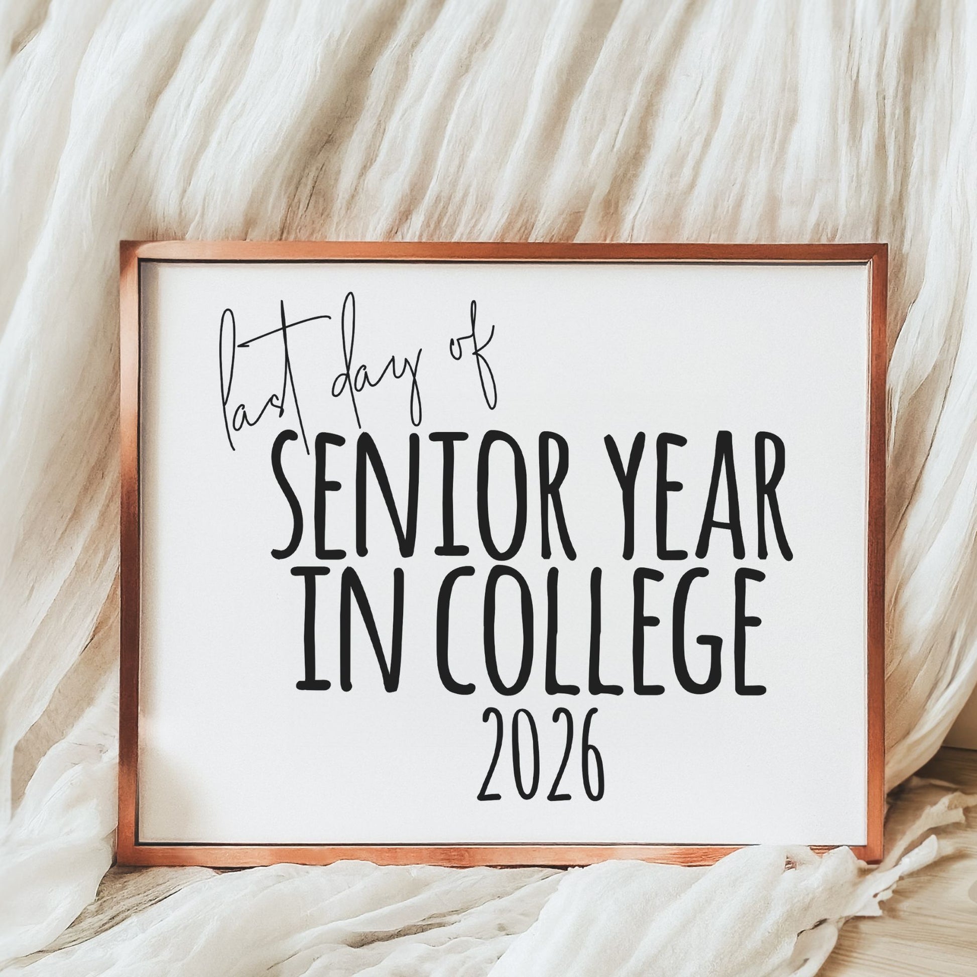 Framed sign with 'Last day of Senior Year in College 2026' text on a soft fabric background