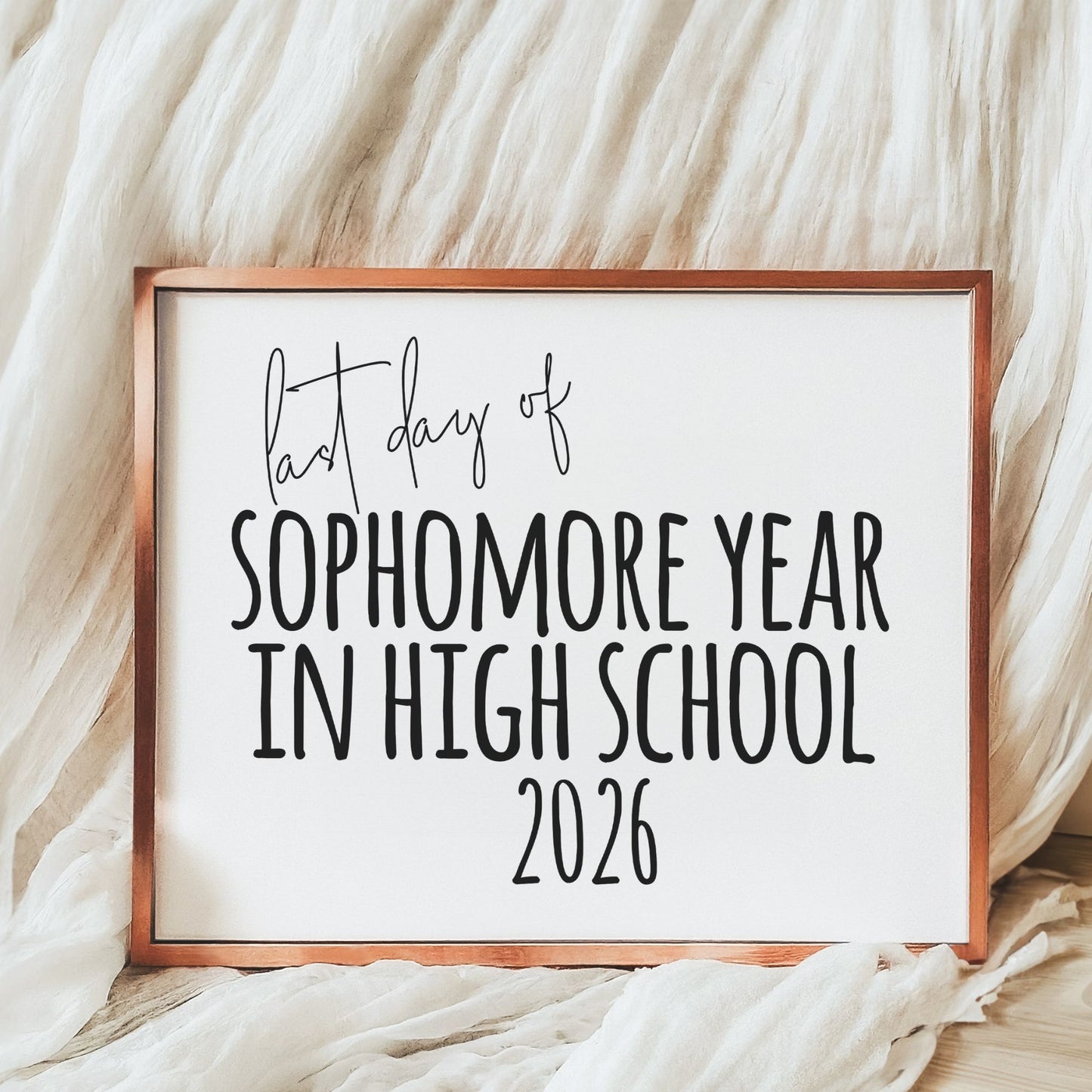 Framed sign with text 'Last day of sophomore year in high school 2026' on a soft white background