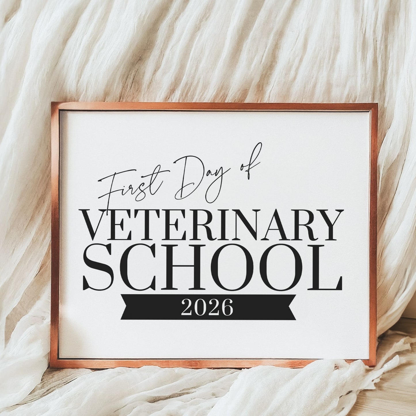 Framed sign with 'First Day of Veterinary School 2026' text on a soft white background