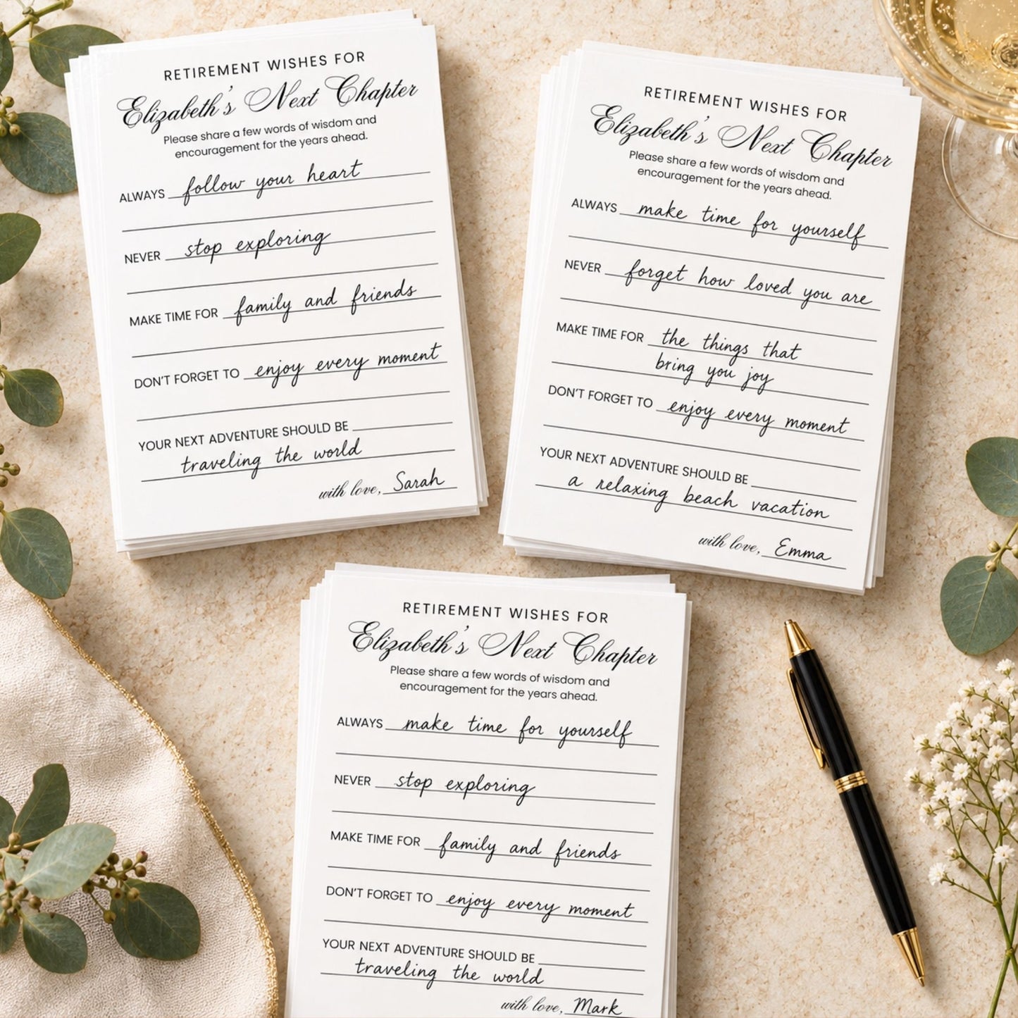 Three printed retirement wishes cards arranged on a light fabric surface with decorative eucalyptus leaves and a gold pen. The cards are white with black text and lined writing areas, and the title reads 'RETIREMENT WISHES FOR Elizabeth's New Chapter.