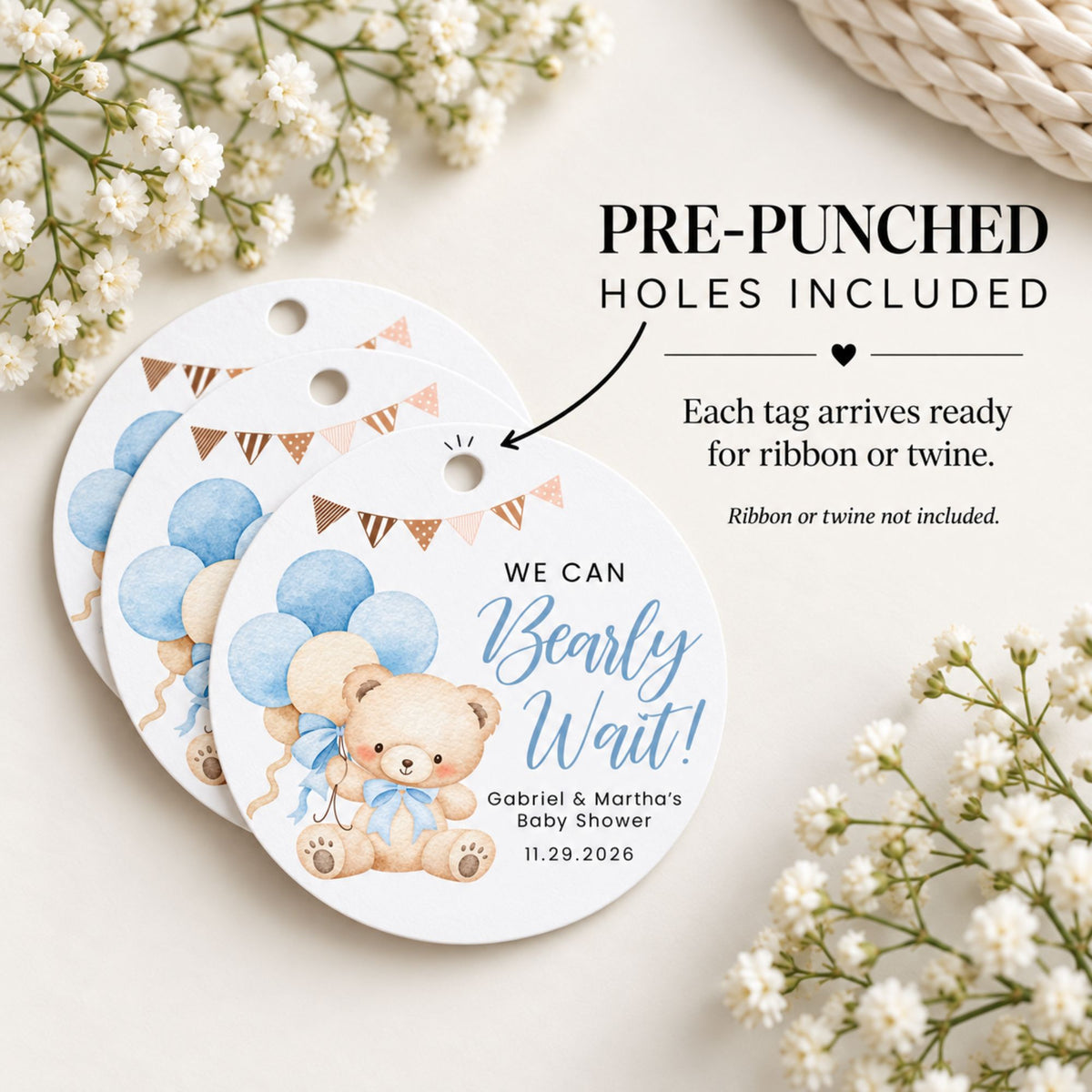 Three round baby shower favor tags with a cute teddy bear and blue balloons design, displayed on a light beige background with white flowers. Text on the image states 'PRE-PUNCHED HOLES INCLUDED' and 'Each tag arrives ready for ribbon or twine.