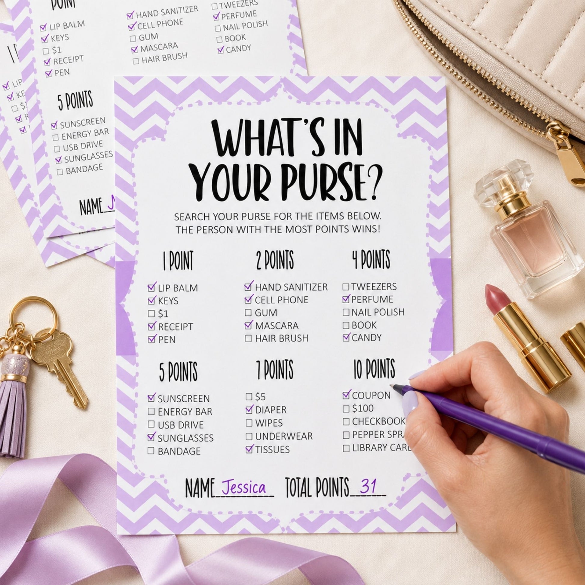 A printed party game card titled "WHAT'S IN YOUR PURSE?" with a lavender and white chevron border, shown on a tabletop with a hand filling out checkboxes. Surrounding props include a white handbag, perfume bottles, keys, and a tassel accessory.
