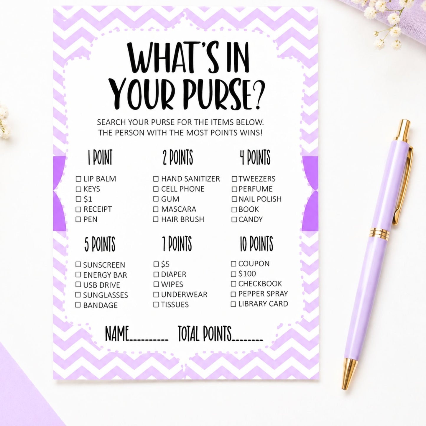 A purple and white chevron bingo game card titled 'WHAT'S IN YOUR PURSE?' shown on a white surface with a lavender pen nearby. The card lists various items and point values for a game where the person with the most points wins.