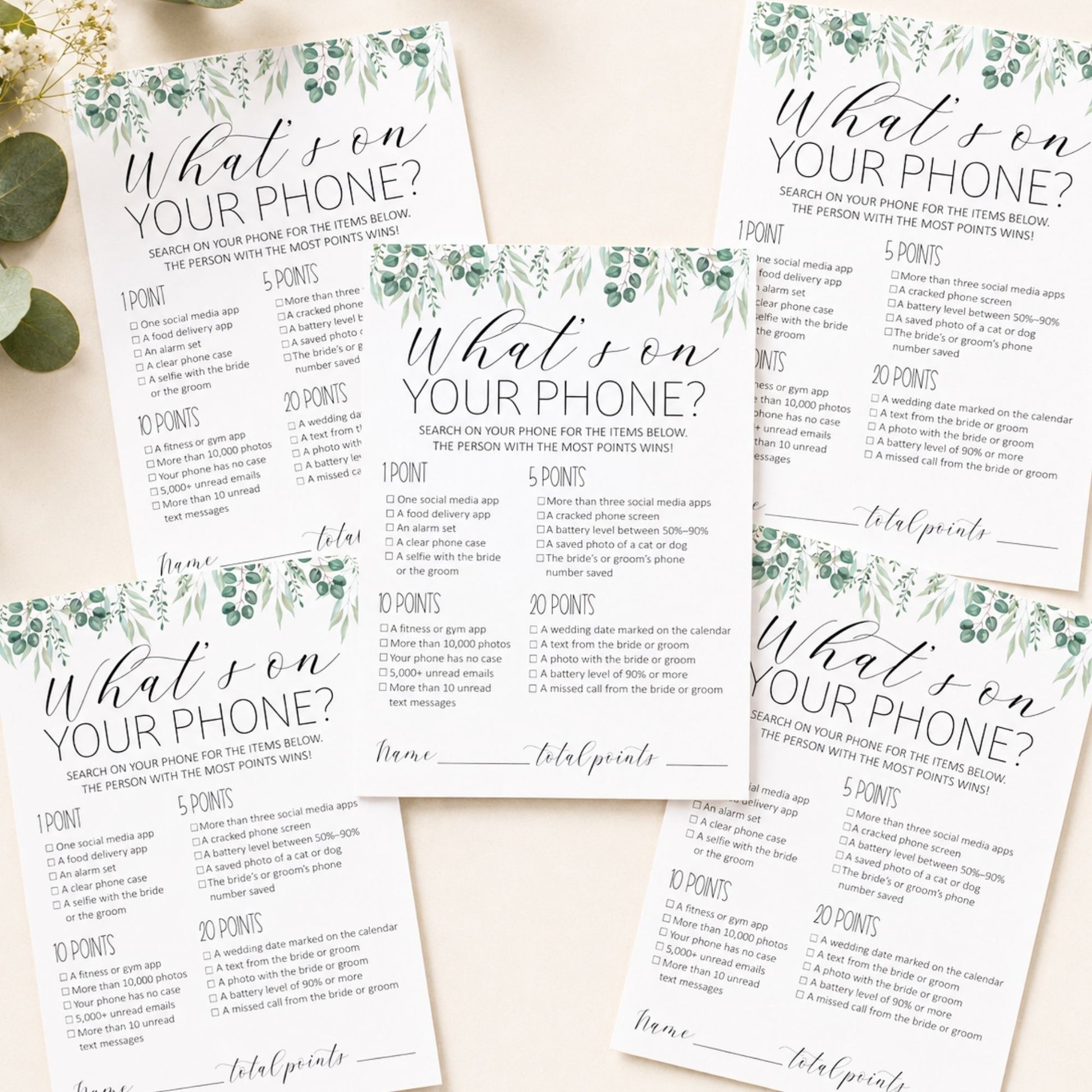 Four printed party game cards titled "What son YOUR PHONE?" arranged on a light neutral background with decorative botanical borders. The cards show scoring sections, checkboxes, and fill-in lines, with a small green leaf prop at the upper left.
