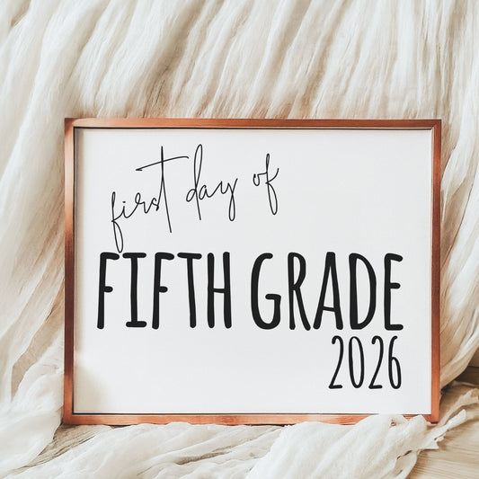 Sign with 'first day of Fifth Grade 2026' text on a soft fabric background