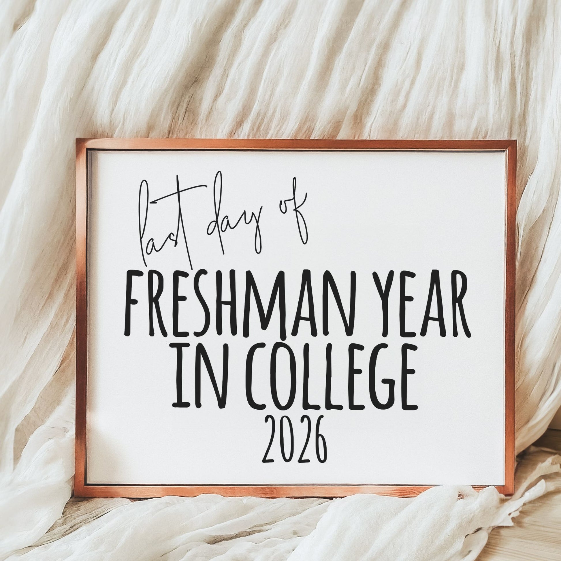 Sign with 'last day of freshman year in college 2026' text on a soft fabric background