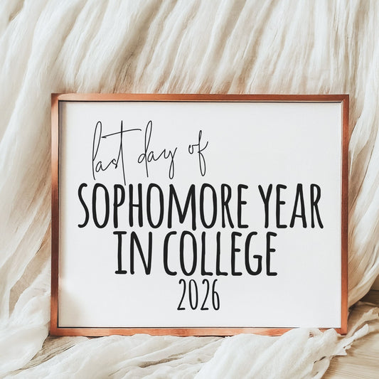 Framed sign with 'last day of sophomore year in college 2026' text on a textured fabric background