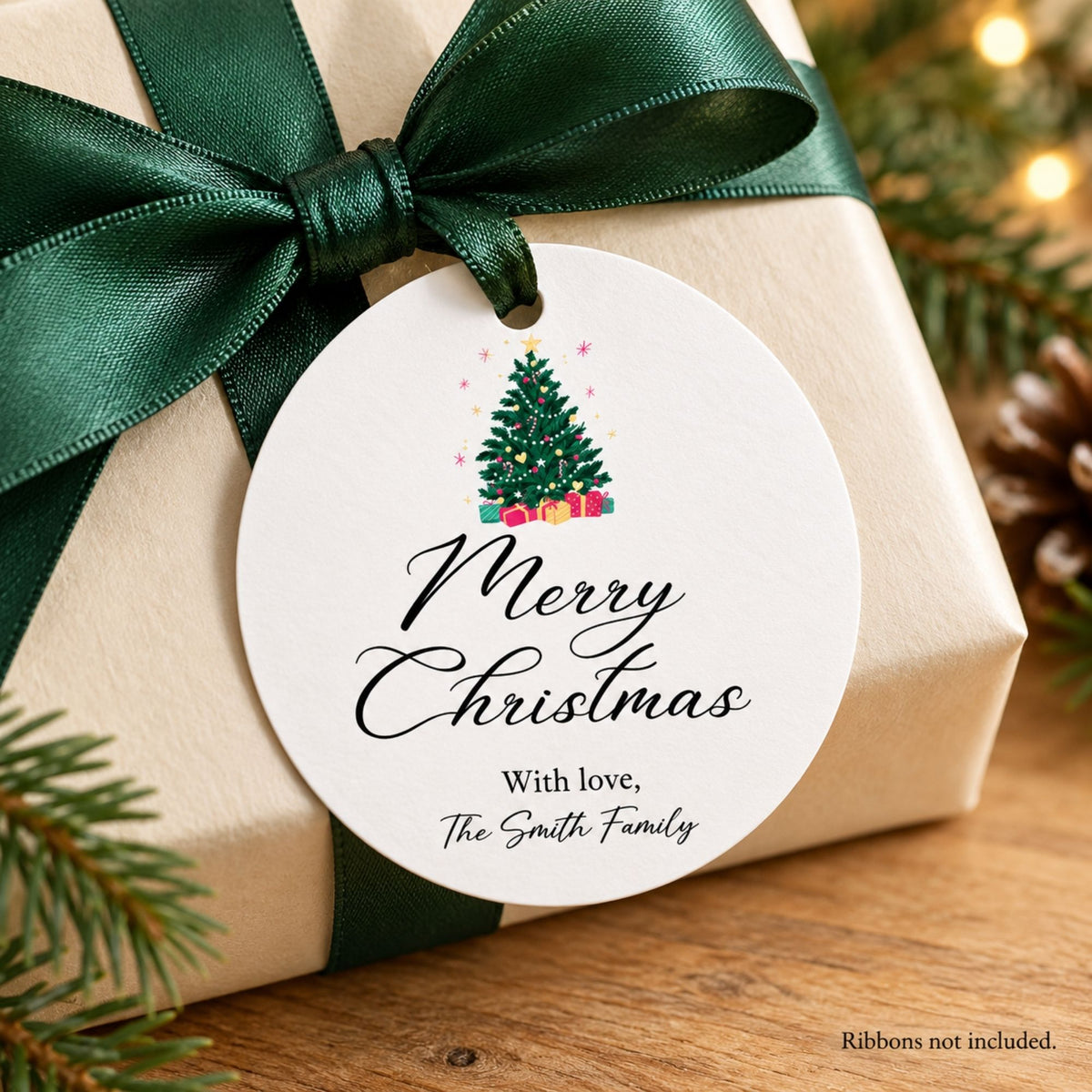 A round white Christmas gift tag with a printed Christmas tree and the words 'Merry Christmas With love, The Smith Family,' attached to a beige wrapped gift box with a dark green ribbon. Pine branches and warm string lights appear around the scene.