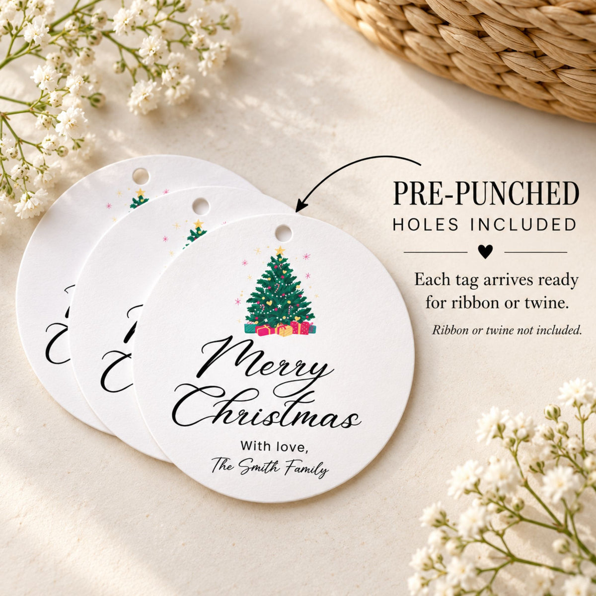 Three round white Christmas gift tags with pre-punched holes are arranged on a light beige surface. The front tag reads “Merry Christmas” with a small Christmas tree illustration and the text “With love, The Smith Family.